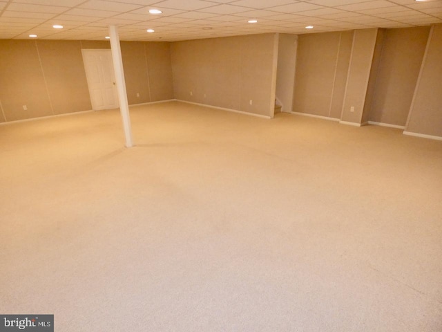 basement with a drop ceiling and carpet