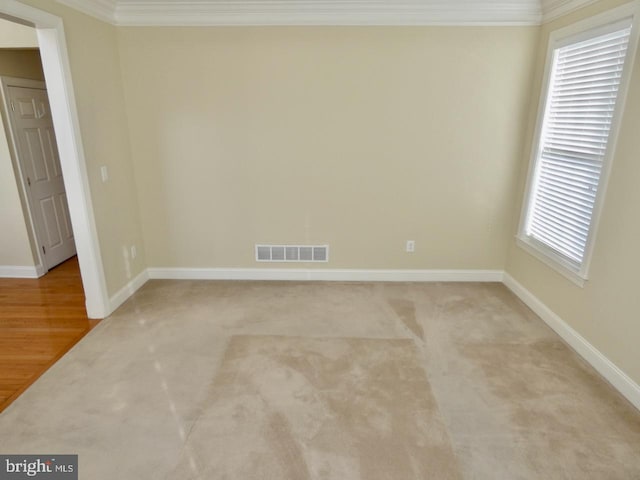 spare room with light hardwood / wood-style floors and crown molding