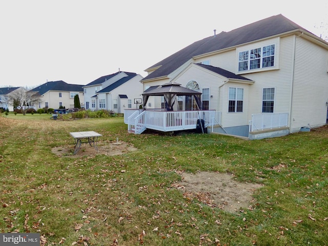 back of house with a deck, a lawn, and a gazebo