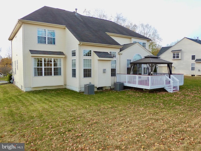 rear view of house featuring central air condition unit, a lawn, and a gazebo