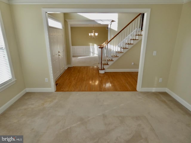 entrance foyer with a chandelier, hardwood / wood-style flooring, and ornamental molding