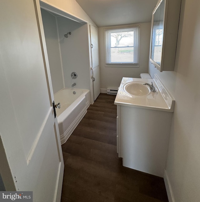 bathroom with vanity, hardwood / wood-style flooring, baseboard heating, and shower / bathtub combination