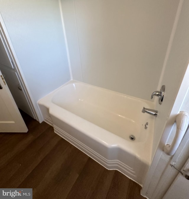 bathroom with hardwood / wood-style floors and a washtub