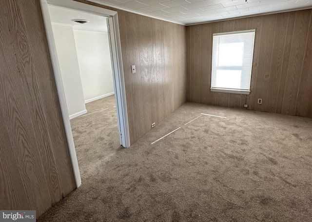 carpeted empty room with wood walls