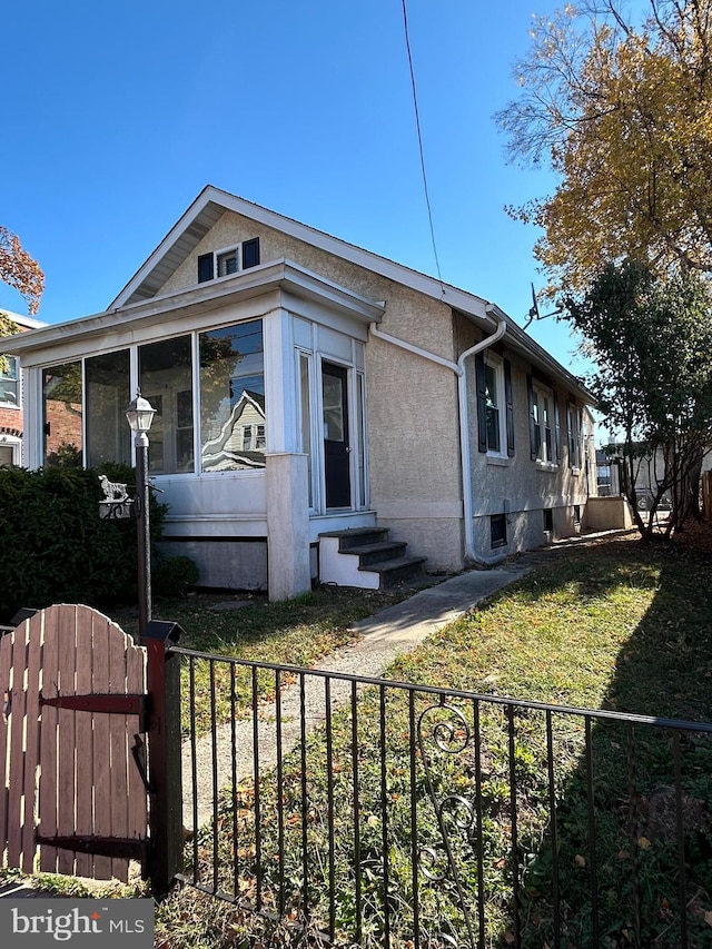 view of side of home featuring a yard and a sunroom