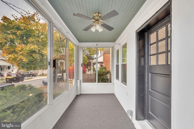 unfurnished sunroom with wood ceiling and ceiling fan