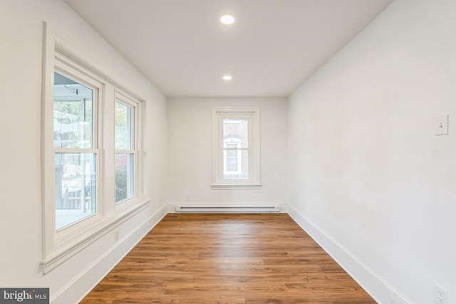 spare room with baseboard heating and hardwood / wood-style floors