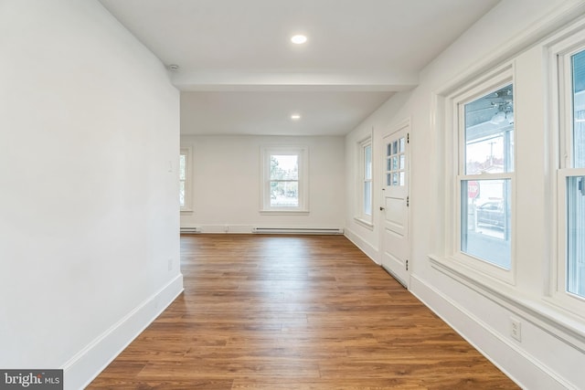 empty room with hardwood / wood-style floors and baseboard heating