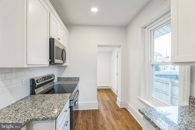 kitchen featuring appliances with stainless steel finishes, wood-type flooring, and white cabinetry