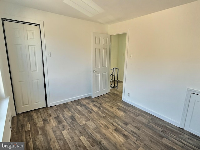 unfurnished bedroom featuring dark hardwood / wood-style flooring and a closet