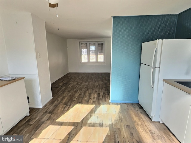 kitchen featuring hardwood / wood-style floors, ceiling fan, white cabinetry, and white refrigerator