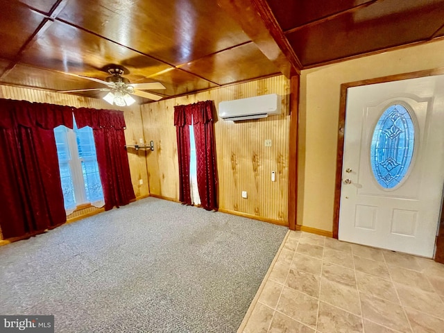 entryway with wooden walls, a wall unit AC, light colored carpet, and ceiling fan