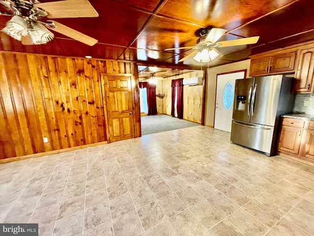 kitchen with ceiling fan, tasteful backsplash, stainless steel fridge with ice dispenser, and wooden walls