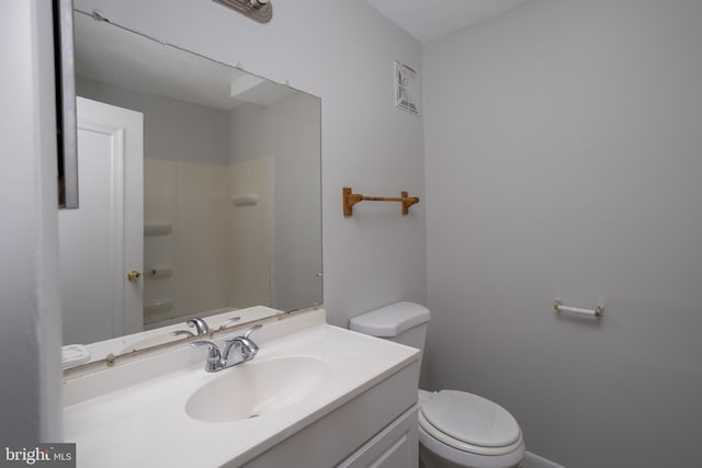 bathroom with vanity, a shower, and toilet