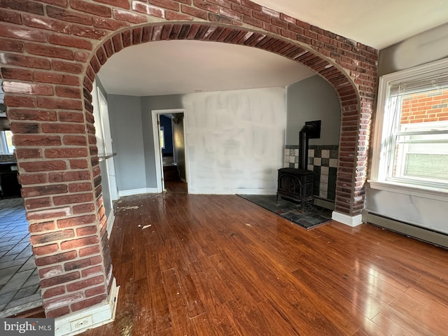 unfurnished living room with hardwood / wood-style flooring and a wood stove