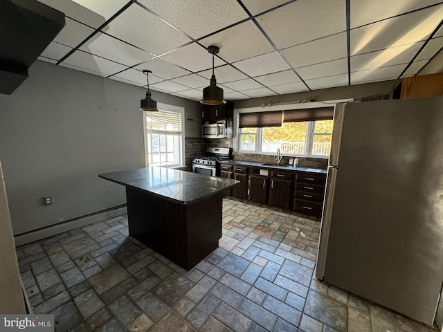 kitchen with dark brown cabinets, a center island, a paneled ceiling, stainless steel appliances, and pendant lighting