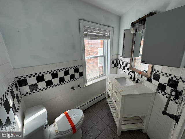 bathroom featuring toilet, tile patterned flooring, a baseboard radiator, vanity, and tile walls