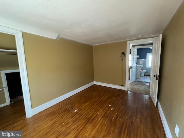 empty room with dark hardwood / wood-style flooring