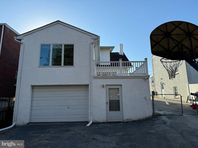 back of house featuring a garage and a balcony