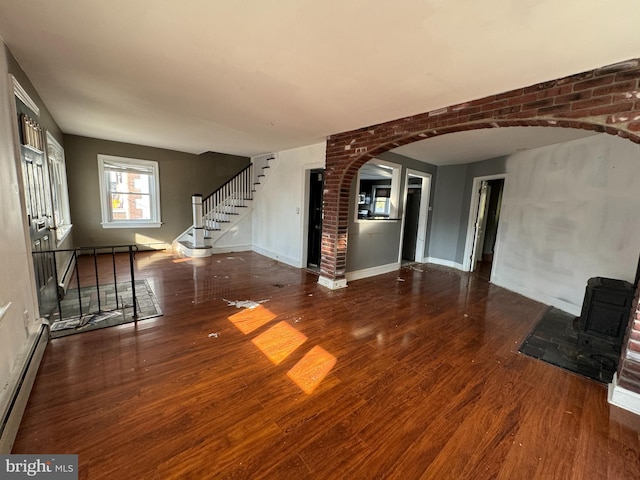 unfurnished living room with wood-type flooring and baseboard heating