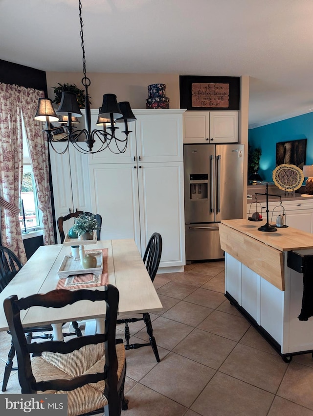dining space featuring an inviting chandelier and light tile patterned flooring