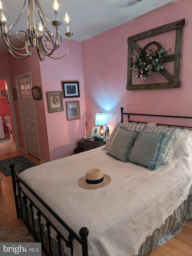 bedroom featuring hardwood / wood-style flooring and an inviting chandelier