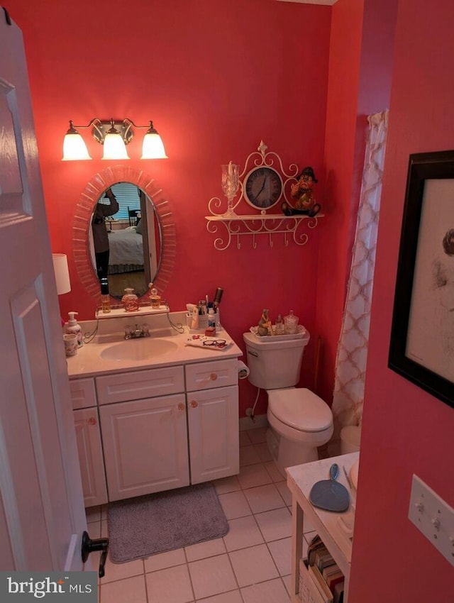 bathroom with vanity, toilet, walk in shower, and tile patterned flooring