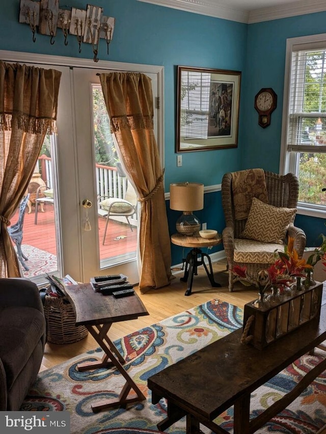 sitting room with ornamental molding and hardwood / wood-style floors