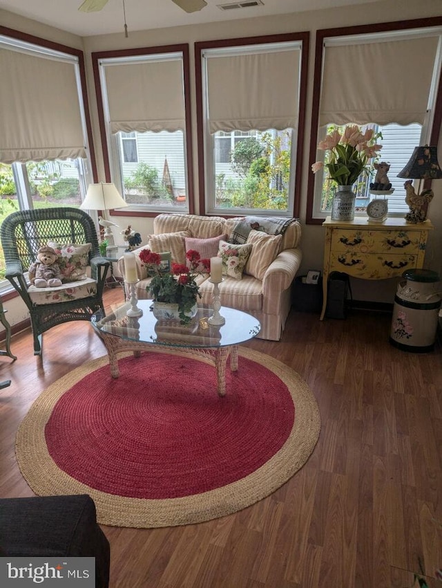 living room featuring ceiling fan, a wealth of natural light, and dark hardwood / wood-style floors