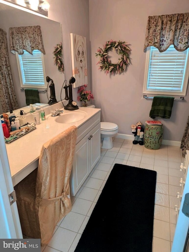 bathroom featuring vanity, toilet, baseboards, and tile patterned floors