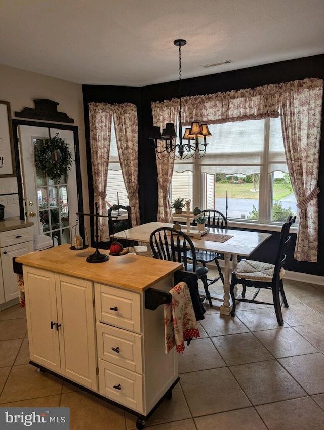 tiled dining space with a chandelier