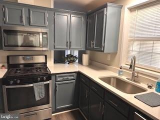 316 Thunderbird Dr, Lusby, MD 20657 - kitchen featuring light countertops, appliances with stainless steel finishes, gray cabinetry, and a sink