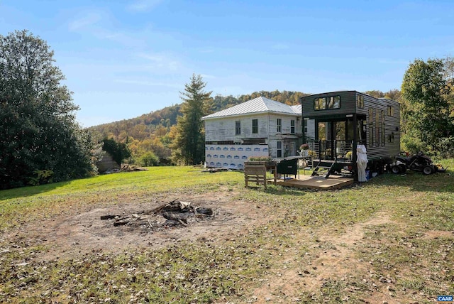 back of house with a yard and a mountain view