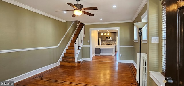 interior space featuring crown molding, hardwood / wood-style flooring, and ceiling fan