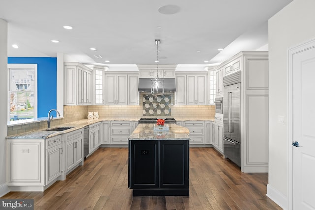 kitchen featuring dark hardwood / wood-style floors, sink, pendant lighting, and a center island