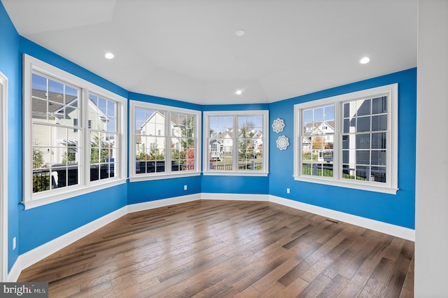 unfurnished room with hardwood / wood-style floors and a healthy amount of sunlight