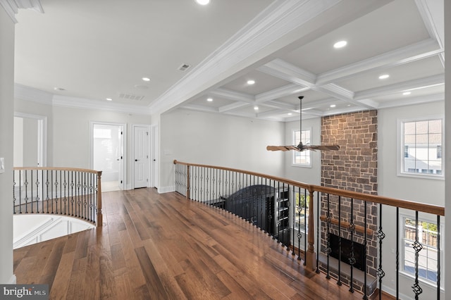 hall featuring beamed ceiling, wood-type flooring, crown molding, and coffered ceiling