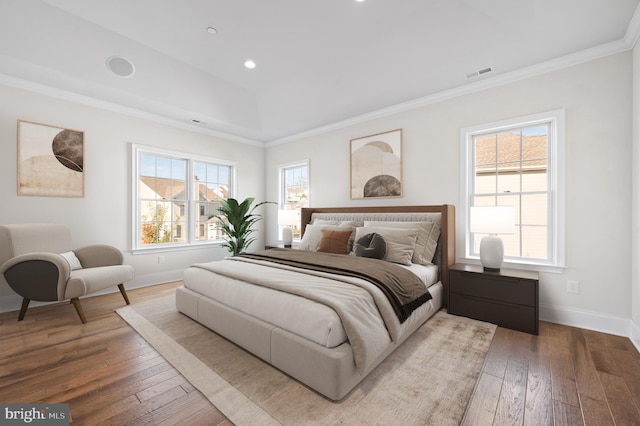 bedroom featuring wood-type flooring, multiple windows, and crown molding