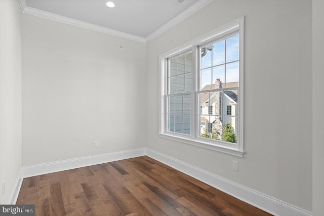 empty room featuring dark wood-type flooring and ornamental molding