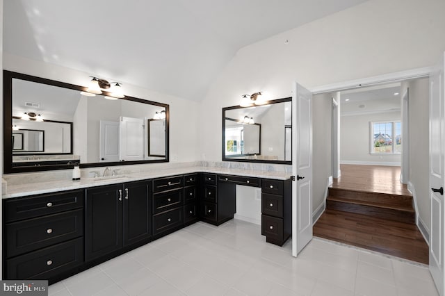 bathroom with wood-type flooring, vanity, and vaulted ceiling