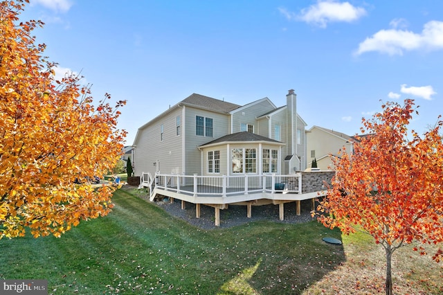 rear view of property with a wooden deck and a yard