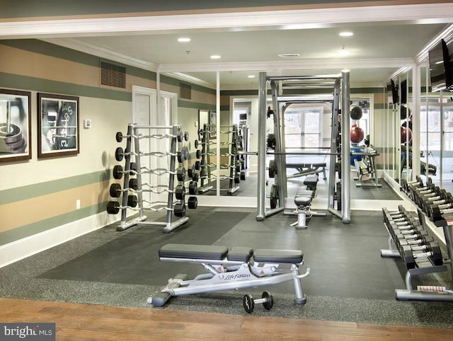 exercise room with a healthy amount of sunlight and crown molding