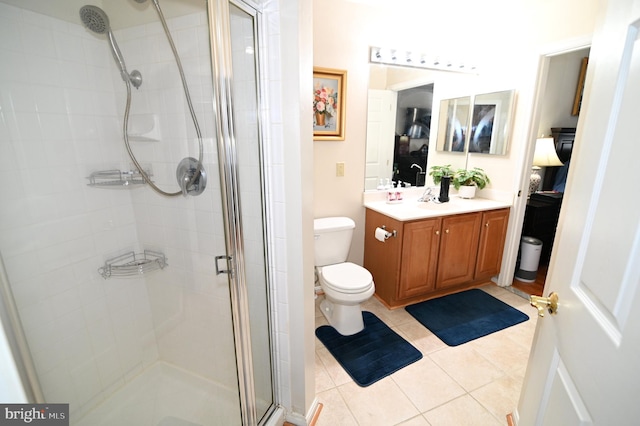 bathroom with vanity, an enclosed shower, toilet, and tile patterned flooring