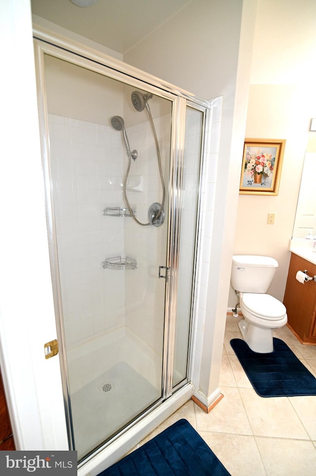 bathroom featuring vanity, toilet, tile patterned floors, and walk in shower