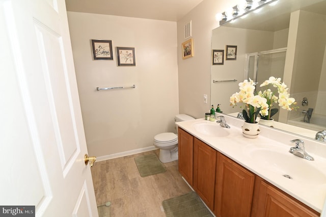 bathroom featuring vanity, wood-type flooring, toilet, and walk in shower