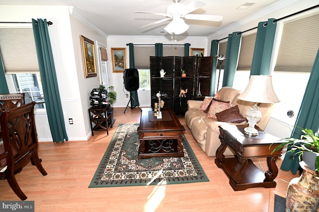 living room with ornamental molding, light hardwood / wood-style floors, and ceiling fan