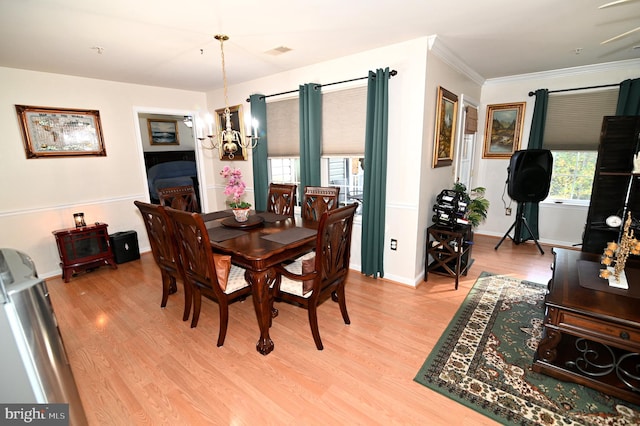 dining space with ornamental molding, a notable chandelier, and wood-type flooring