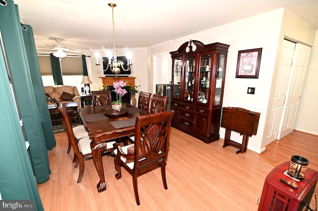 dining area with ornamental molding, light hardwood / wood-style flooring, and ceiling fan with notable chandelier