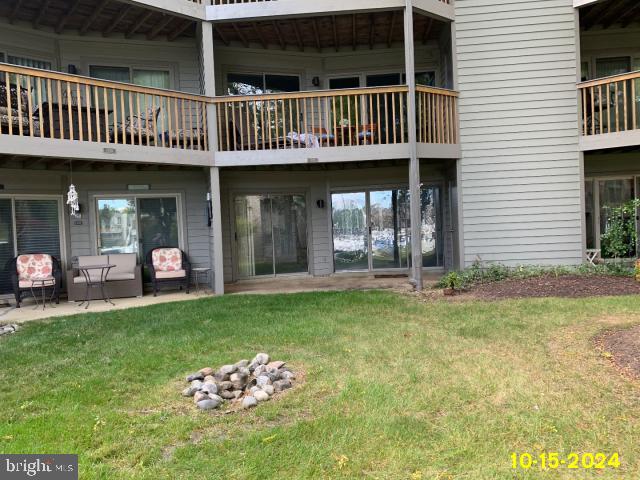 rear view of house featuring a lawn and a patio