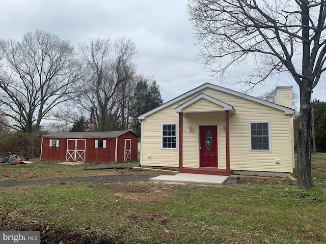 view of front facade featuring a shed and a front yard